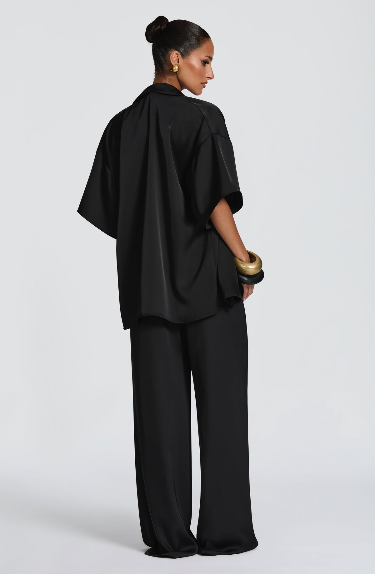 Pantalón negro de pierna ancha, cintura con cordones fruncidos.