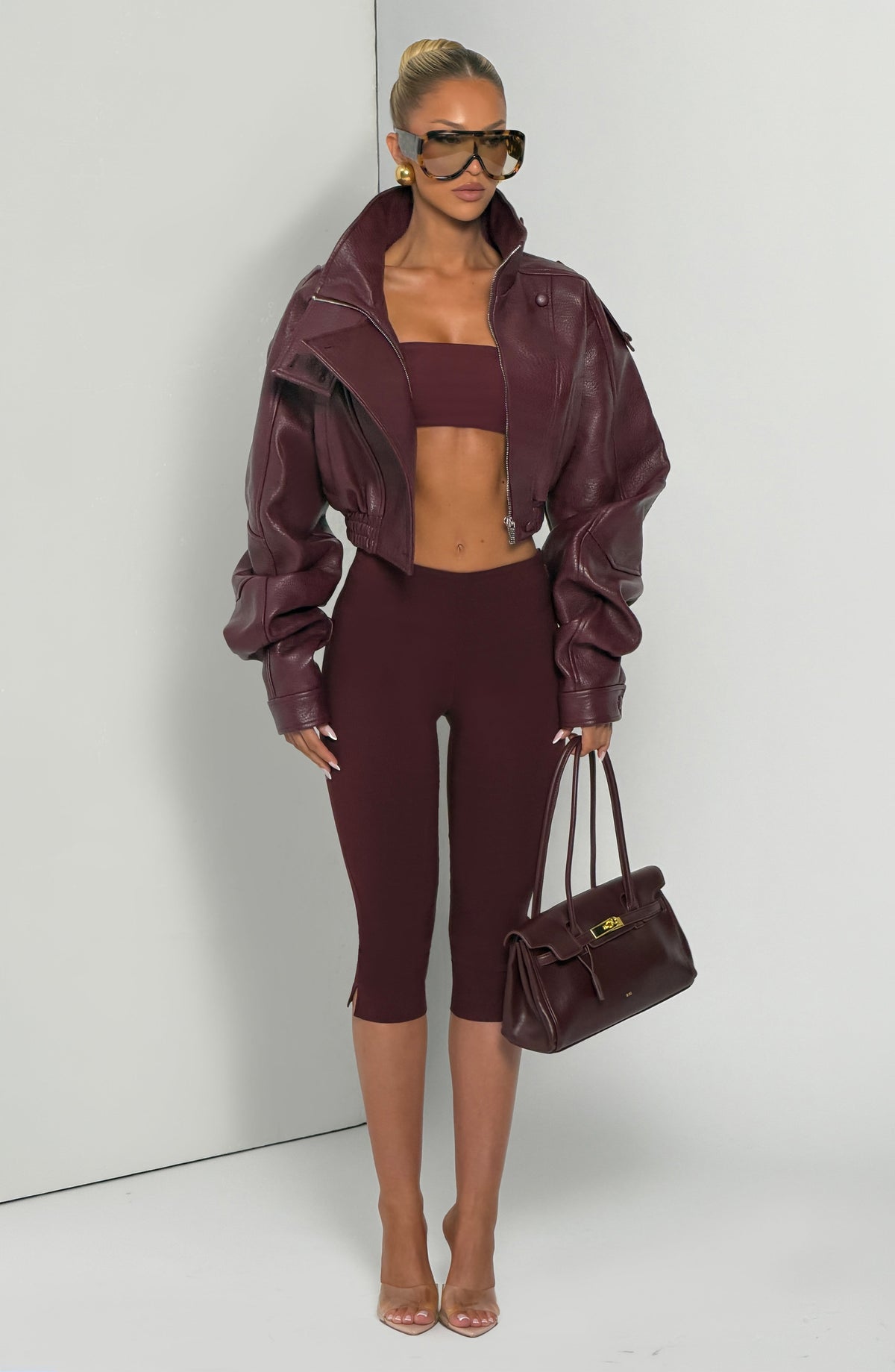 Pantalón capri rojo oscuro ceñido con tiro alto y largo hasta la rodilla