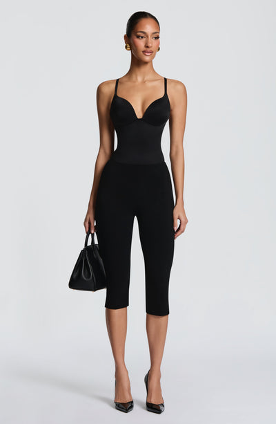 Mono capri negro con escote corazón y tirantes finos, pantalón 3/4 entallado