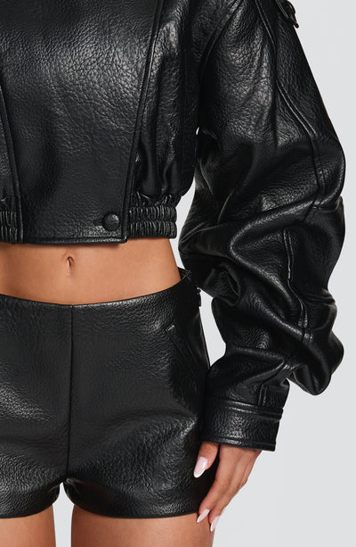 Pantalón corto negro de cuero con dobladillo elástico y costuras