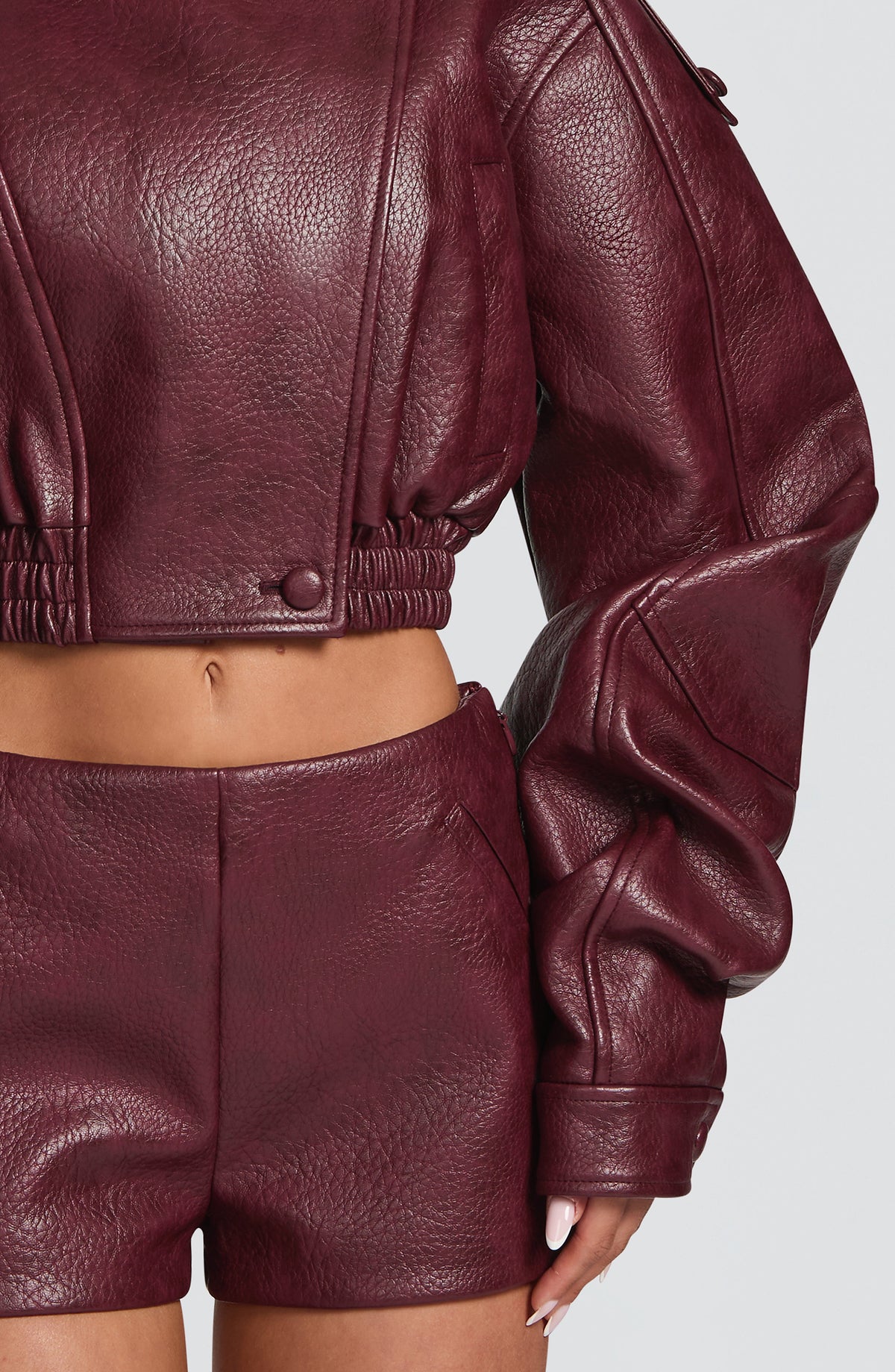 Pantalón corto rojo cereza de cuero con textura granallada y cierre con botones