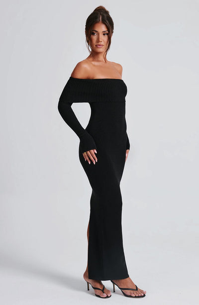 Vestido negro ajustado con escote off-shoulder y abertura en la pierna, vista lateral