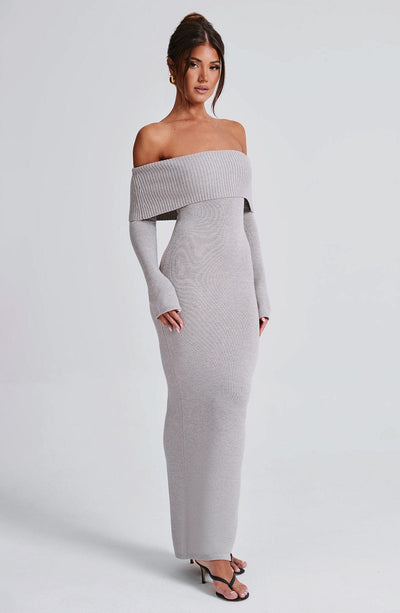 Vestido largo de punto gris claro con escote off-shoulder y falda ajustada hasta el suelo.