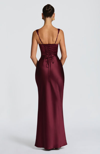 Vestido largo satinado burdeos con espalda descubierta y lazos en la cintura