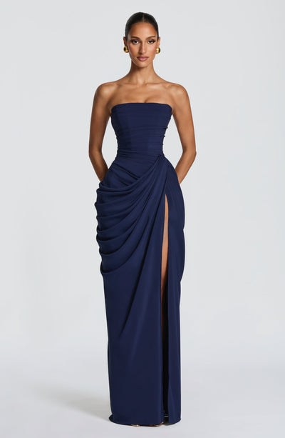 Vestido largo azul oscuro strapless con drapeado lateral, textura fruncida y abertura larga.
