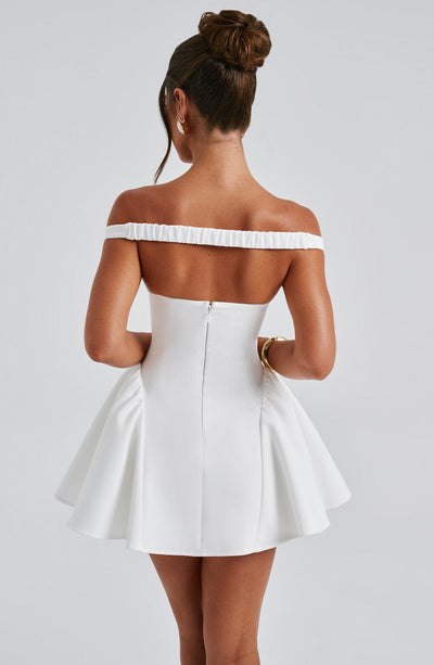 Vestido blanco con espalda descubierta, cinturilla fruncida y falda con vuelo