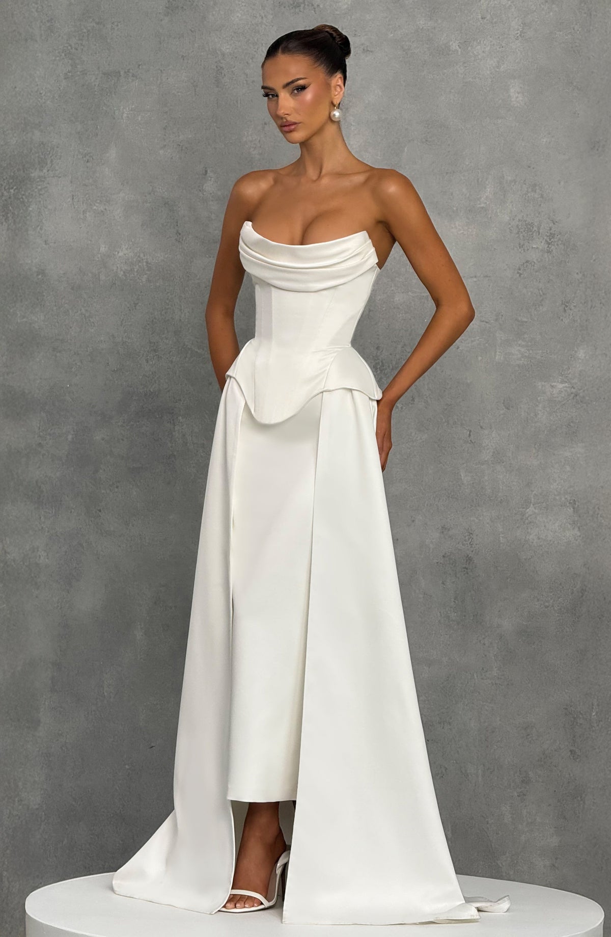 Vestido marfil con cola y peplum drapeado, falda acampanada y abertura