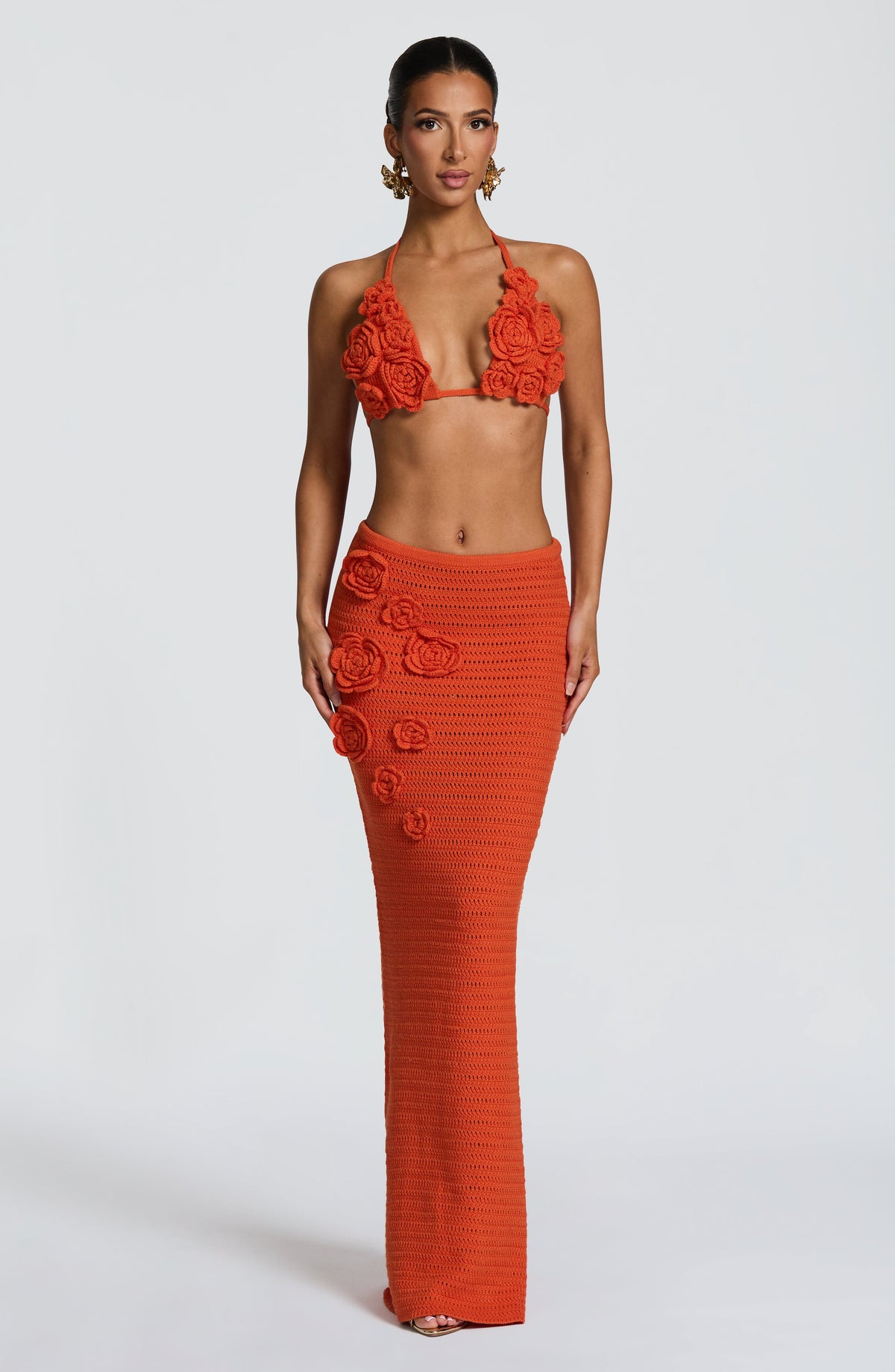Falda larga naranja de punto con apliques florales 3D en la cintura.