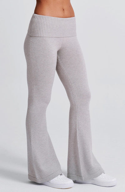 Pantalón de punto gris claro con pierna acampanada y costura a lo largo del muslo.