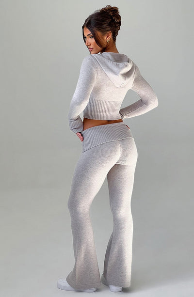 Pantalón acampanado de punto gris claro, cintura elástica y piernas con aberturas laterales.