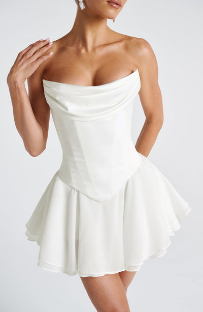 Vestido corto marfil con escote bandeau y falda acampanada con volantes